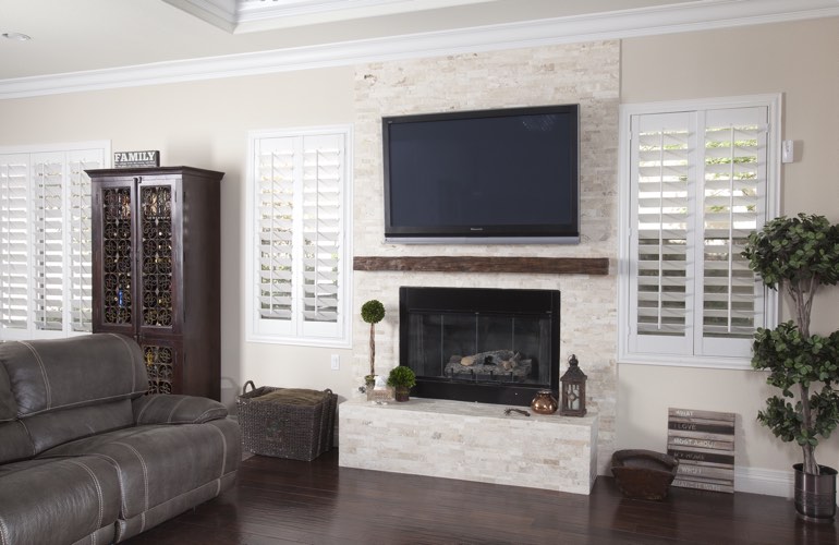 White plantation shutters in a Seattle living room with dark hardwood floors.